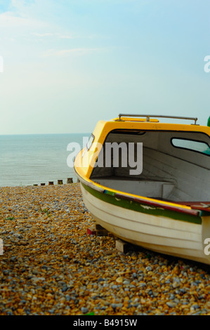 Piccolo giallo barca da pesca sulla spiaggia ricorda al mare. Foto Stock