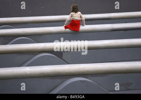 Giovane ragazza seduta sulla più lunga deuropa altalena in Tilla-Durieux-Park, Berlino, Germania Foto Stock