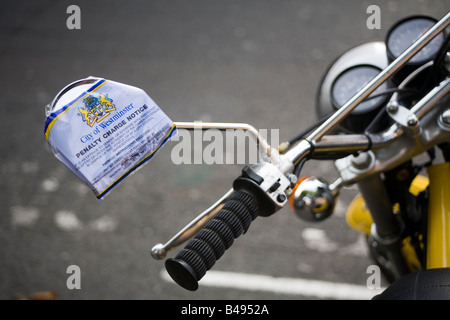 City of Westminster penalità avviso attaccato intorno allo specchio di una moto parcheggiata su un assolo di motocicli parcheggio bay Londra Foto Stock