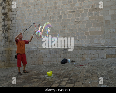 Performer di strada facendo gigantesche bolle di sapone. Foto Stock