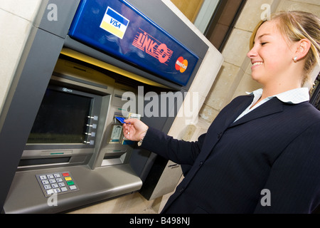 Donna che utilizza un collegamento bancomat ATM cash point REGNO UNITO Foto Stock