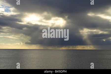 Stormclouds e sunray sull'oceano Foto Stock