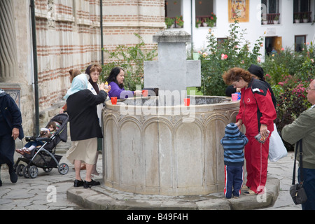 Cozia Transilvania Romania Europa settembre adoratori di raccolta e di bere acqua santa a Cozia monastero costruito nel 1388 Foto Stock