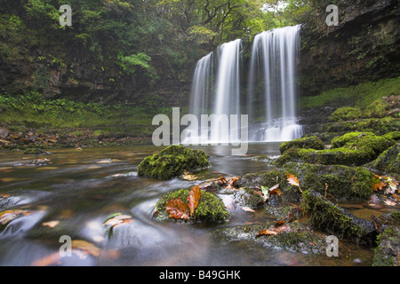 Sgwd yr Eira cascata con foglie di quercia e moss rocce coperte in primo piano in Brecon Beacon National Park, il Galles in settembre. Foto Stock