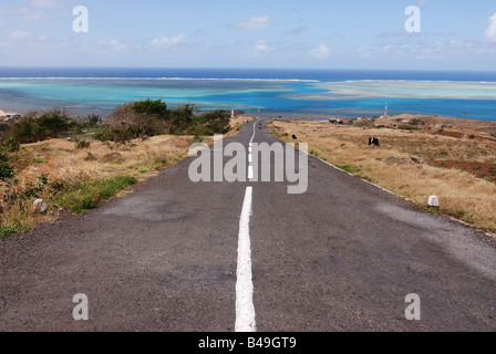 Strada che conduce verso il basso di una montagna in direzione delle acque turchesi dell'Oceano Indiano Rodrigues isola Maurizio Foto Stock