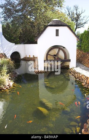 Antico mulino ad acqua vicino alla cantina a Plaisir de Merle Sud Africa su una soleggiata giornata d'estate Foto Stock