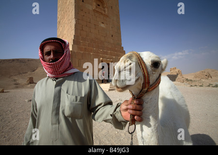 Uomo con il cammello di fronte alla funeraria romana torri nella Valle del Tombe, Palmyra, Siria Foto Stock