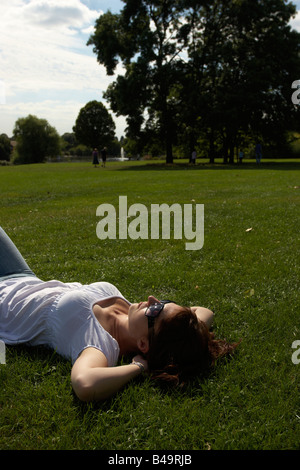 La donna a prendere il sole nel parco Foto Stock