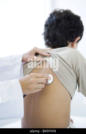 Medico collocando uno stetoscopio sul ragazzo del retro, vista ritagliata Foto Stock