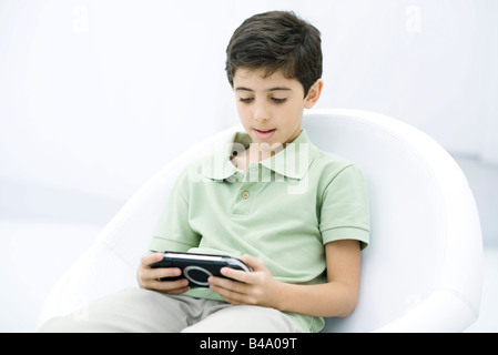 Ragazzo giocando palmare video gioco Foto Stock