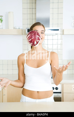 Donna con testa di radicchio cicoria caduta anteriore del suo viso Foto Stock