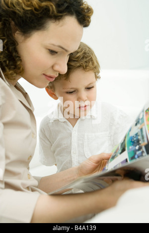 Madre e figlio toddler la lettura del libro di fumetti di insieme Foto Stock