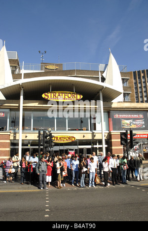Le persone in attesa di attraversare la strada di fronte al centro commerciale a Stratford London. Foto Stock
