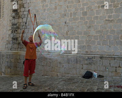 Performer di strada facendo gigantesche bolle di sapone. Foto Stock