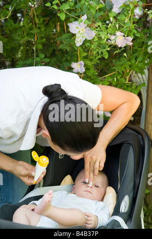 La mamma mette sun-crema il bimbo di faccia Foto Stock