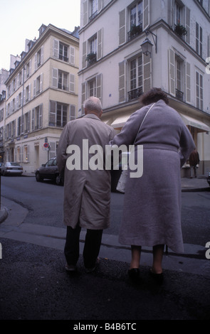 Coppia senior attraversando la strada Foto Stock