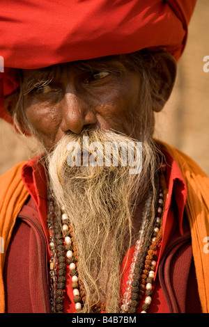 Il barbuto volto di Suchdev Baba Santi un Sadhu in Varanasi. Egli indossa una grande turbante rosso in cui i suoi capelli lunghi è avvolto. Foto Stock