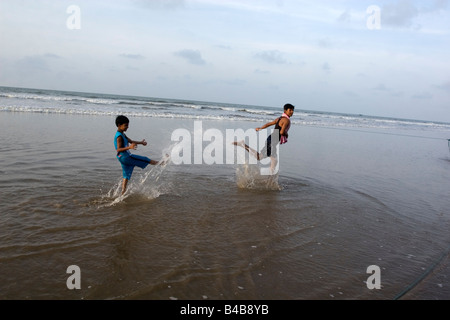 Due ragazzi stanno godendo il bagno presso la spiaggia di Digha, Bengala Occidentale,l'India Foto Stock