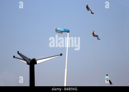 Tre uomini persone appendere arrampicata la linea di corda lampione blue sky sport all'aperto ad alta altitudine pericolo fun Foto Stock