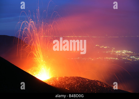 Eruzione vulcanica da Mt. Il vulcano Etna, Sicilia, nella serata con luci di Taormina e Giarre sullo sfondo Foto Stock