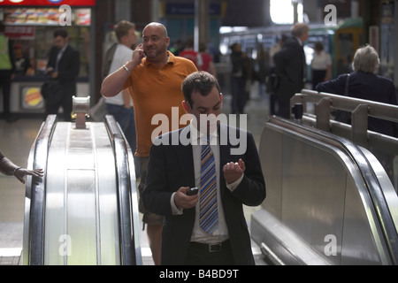 Rush Hour pendolari treno scendere dalla scala mobile in metropolitana a Londra London Bridge Mainline Station en-route al tubo sevices Foto Stock