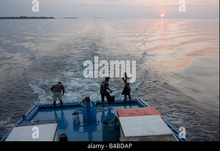 L'equipaggio a bordo di un tradizionale dhoni barca da pesca a prepararsi per un altro giorno di pesca del tonno dell'Oceano Indiano Maldive Foto Stock