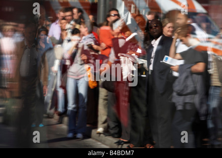 Visto attraverso un bus shelter finestra Coda di pendolari per autobus durante 3 giorni di sciopero del tubo e una città canicola Foto Stock