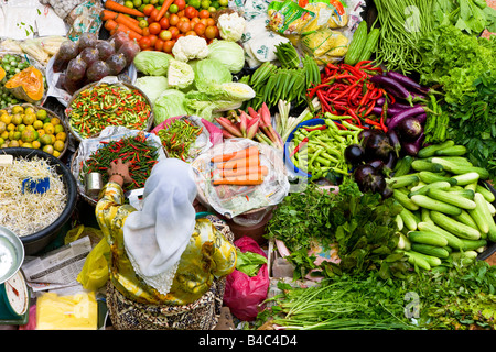 Asia, Malaysia, Kelantan Stato, Kota Bharu, donna per la vendita di frutta e verdura nelle città mercato centrale Foto Stock