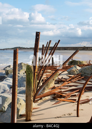 Le difese del mare piegato e contorto dalla azione di onda. Protetto da rocce di happisburgh norfolk Inghilterra Foto Stock