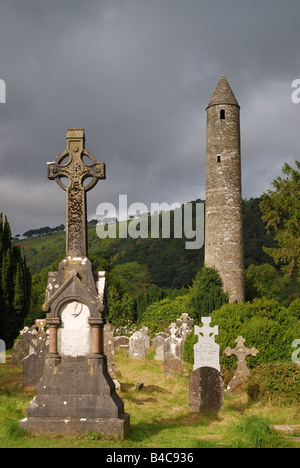 Croce celtica con torre monastica in background a sunrise di Glendalough Monti Wicklow Irlanda Foto Stock