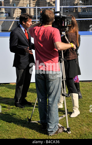 Cameraman al lavoro le riprese di intervista con il Signore Seb Coe in TV premere intervista al di fuori del Municipio di Londra 2012 promozione olimpica Foto Stock
