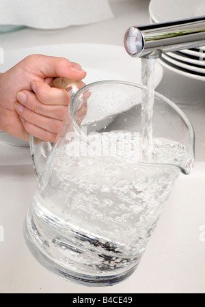 Donna bricco per il riempimento con acqua del rubinetto Foto Stock