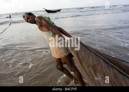 Un pescatore impegnato in attività di pesca a Digha,West Bengal,l'India Foto Stock