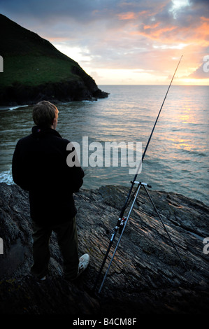 Ragazzo di pesca al tramonto nella Baia di Baia CWMTYDU CEREDIGION West Wales UK Foto Stock