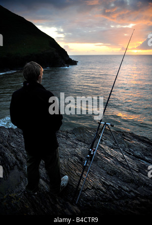 Ragazzo di pesca al tramonto nella Baia di Baia CWMTYDU CEREDIGION West Wales UK Foto Stock