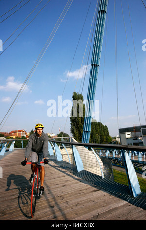 Il ragazzo corse la sua red bike attraversando un ponte. Foto Stock