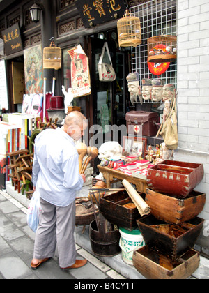 Un uomo di shopping in Panjiayuan Mercato delle Pulci a Pechino, Cina Foto Stock