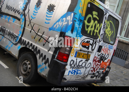 Strada urbana scena con soggetto ad atti vandalici coperto di graffiti minivan parcheggiate lungo la strada a Lille Francia Foto Stock