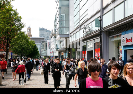 Agosto 2008 - persone a piedi lungo la strada del mercato con molti negozi Manchester Inghilterra England Regno Unito Foto Stock