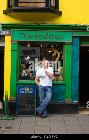 Regno Unito Inghilterra Somerset Glastonbury High Street uomo in attesa fuori la dea shop Foto Stock