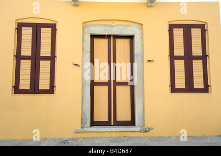 Una vecchia casa con porte chiuse e finestre sull'isola greca di Symi Grecia Foto Stock