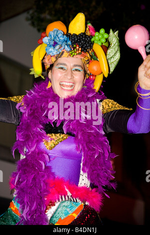 Un gioioso carnevale intrattenitore aiuta la folla divertirsi in una strada di carnevale. Foto Stock