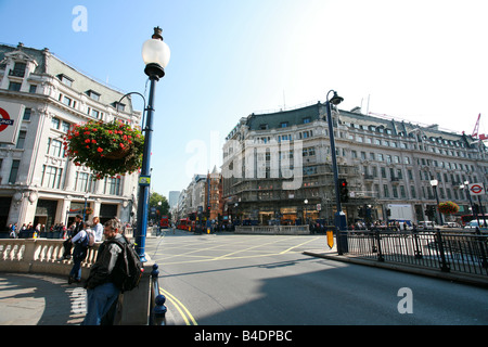 I turisti shopping in Oxford Circus dove Oxford Street e Regent Street cross, major London retail area shopping district UK Foto Stock