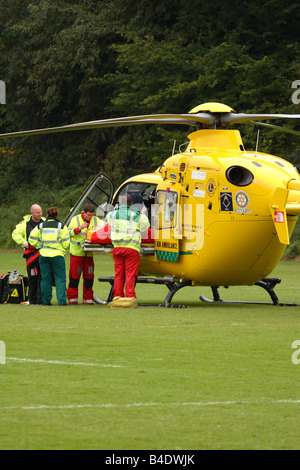 Air Ambulance CE 135 elicottero caricamento di un lesioni sportive incidente su un passo di rugby azionato da Dorset e Somerset Air Ambulance Foto Stock