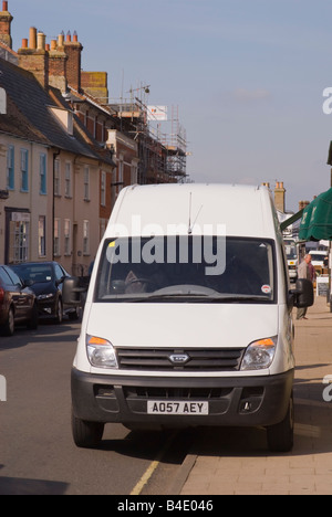 Furgone bianco parcheggiato sul cordolo in high street Foto Stock