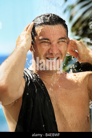Bel uomo felice è prendere una doccia esterna Foto Stock