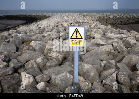 Avviso di pericolo segno per rocce sulla struttura di frangionde Morecambe Lancashire England Regno Unito Foto Stock