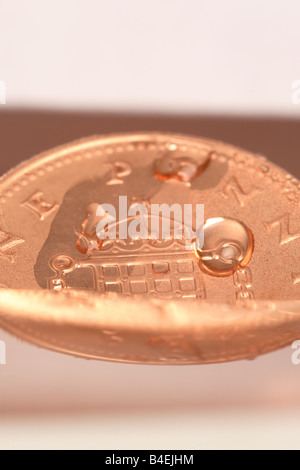 1p penny denaro contante moneta annegamento di affondamento in acqua pericolo finanziario concept Foto Stock