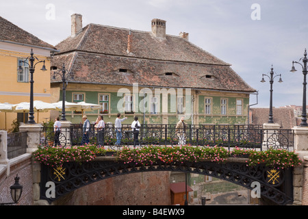 Persone che attraversano il Ponte di Liars in Piata Mica piccola piazza nel centro storico della città di Hermannstadt. Sibiu Transilvania Romania Europa Foto Stock