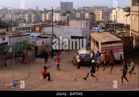 Giovani uomini che giocano a calcio sulla devastazione della città a Luanda, Angola, Africa. Foto Stock